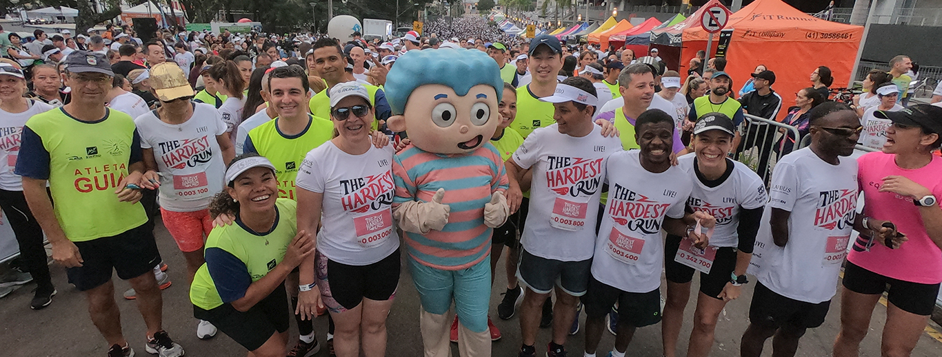 boneco mascote do hospital erastinho acenando junto com os participantes da corrida