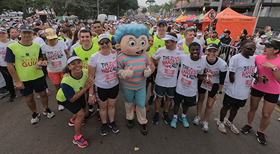 boneco mascote do hospital erastinho acenando junto com os participantes da corrida