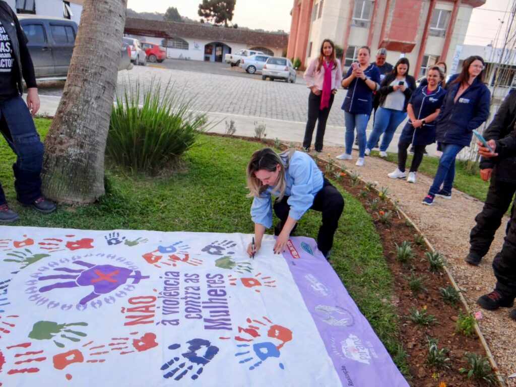 A prefeita de Urubici, Mariza Costa, autografa o banner que exibe dizeres de conscientização contra a violência à mulher. Foto: Filhas do Vento/ Divulgação