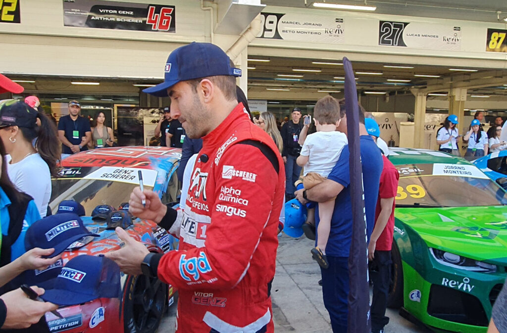 Vitor Genz autografa os bonés MILITEC 1 durante a visitação do público ao box em Interlagos. Foto: Renyere Trovão