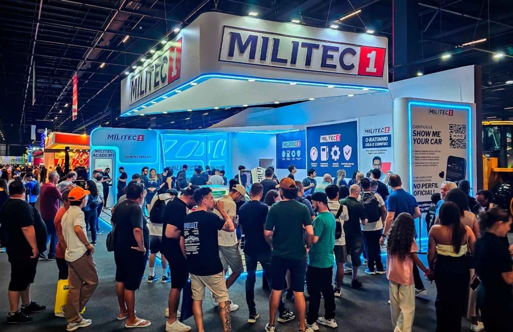 Vista geral do estande da Militec no Salão do Automóvel 2025, com grande público e as atrações ao fundo